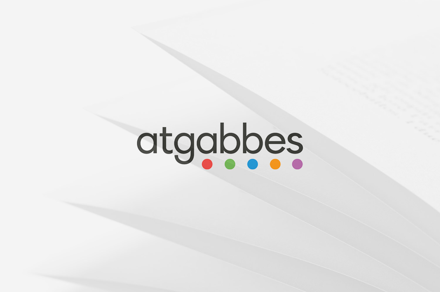 In primo piano il logo di Atgabbes, sullo sfondo le pagine di un libro
